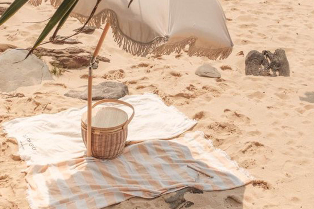 picnic basket with blanket on the beach